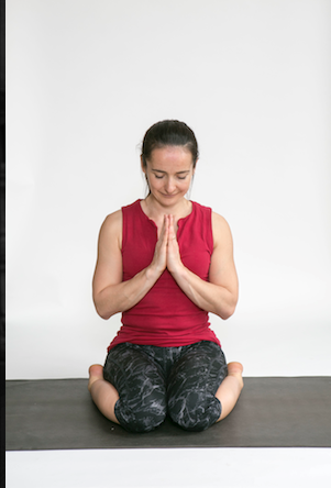 Sophie kneeling with palms together at her chest